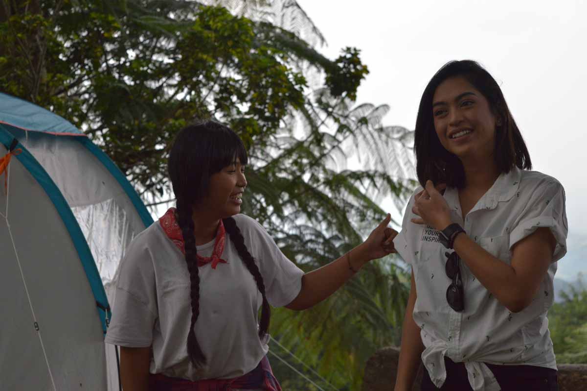 Satya Winnie mengenakan kaos putih dan scarf merah